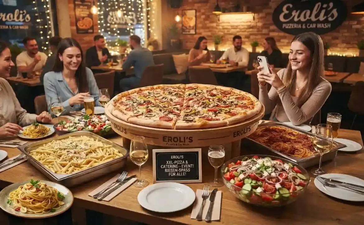 Reichhaltiges Catering-Buffet bei Eroli's Pizzeria & Car Wash mit einer riesigen 90-cm-XXL-Pizza auf einem Holzständer, großen Nudelplatten (Penne und Spaghetti), frischen Salaten und Getränken für ein Event. Gäste sitzen an Tischen und eine Frau fotografiert das Essen.
